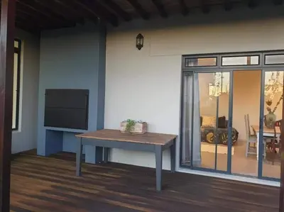 a living room with a table and a tv at 4 Bed Selfcatering River Tree House overlooking the Onrus river in Hermanus