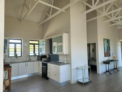 a kitchen with white cabinets and a counter top at 4 Bed Selfcatering River Tree House overlooking the Onrus river in Hermanus