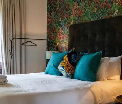 a bedroom with a bed with blue pillows at Plaisir Estate Accommodation in Simondium