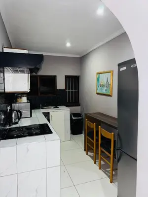 a kitchen with white appliances and a black refrigerator at Mila Lodge 1 in Cape Town