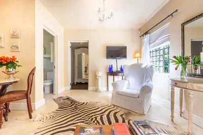 a living room with a zebra rug and a chair at Devon Castle Forest Lodge in Stellenbosch