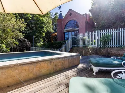a backyard with a swimming pool and a house at Devon Castle Forest Lodge in Stellenbosch
