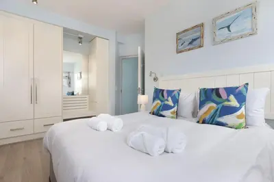 a bedroom with a white bed with towels on it at Pips Place 301 in Strand