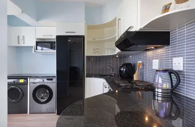 a kitchen with a washer and dryer and a stove at Pips Place 301 in Strand