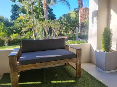 a bench sitting on a porch with a plant at Alimandi Nursery Cottage in Cape Town
