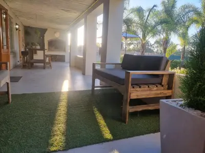 a living room with a couch on the grass at Alimandi Nursery Cottage in Cape Town