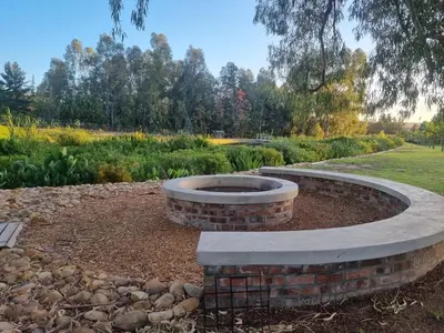 a fire pit in the middle of a garden at Alimandi Nursery Cottage in Cape Town