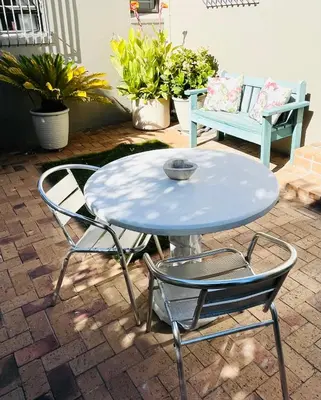 a white table and two chairs and a bench at Sleepy Tides in Cape Town