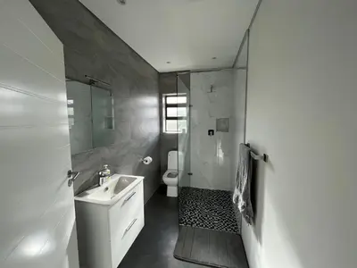a bathroom with a sink and a shower and a toilet at Sleepy Tides in Cape Town