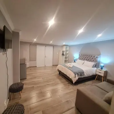 a large bedroom with a bed and a couch at 51 On Vlei in Cape Town