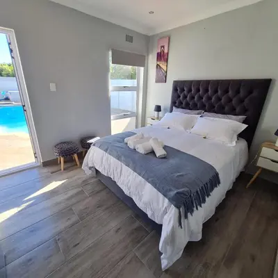 a bedroom with a large bed with a large window at 51 On Vlei in Cape Town