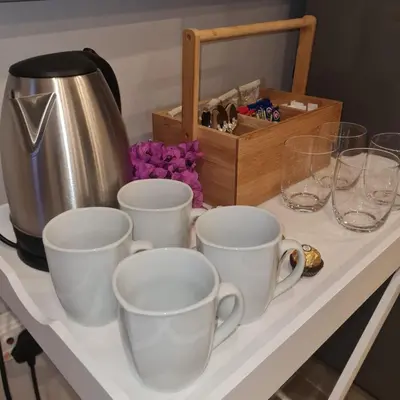 a table with four cups and a tea pot and a box at 51 On Vlei in Cape Town