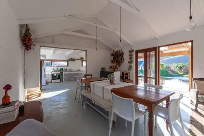 a living room with a bed and a table and chairs at Farmstay at the Goat Shed Cottage, Spinlea Farm in Greyton