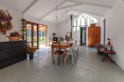 a kitchen and dining room with a table and chairs at Farmstay at the Goat Shed Cottage, Spinlea Farm in Greyton