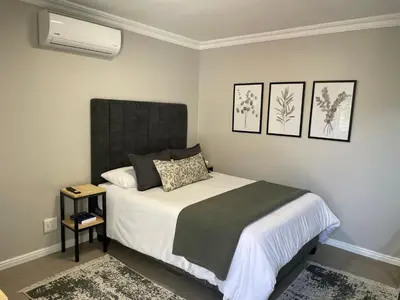 a bedroom with a bed with a black headboard at Stellenbosch Serenity in Stellenbosch