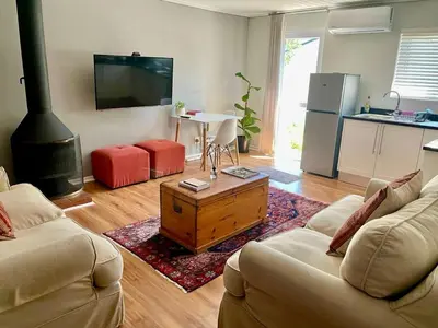 a living room with two couches and a stove at Stellenbosch Serenity in Stellenbosch