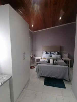 a bedroom with a large bed with a wooden ceiling at Mila Lodge 1 in Cape Town