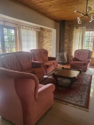 a living room with pink couches and a coffee table at MJ's Guest House in Cape Town