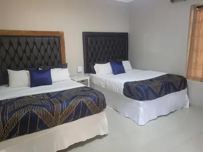 two beds sitting next to each other in a room at MJ's Guest House in Cape Town