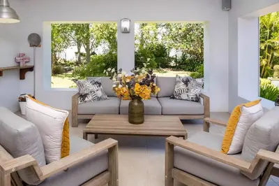 a living room with couches and a table with flowers at Eden-Paradys in Stellenbosch