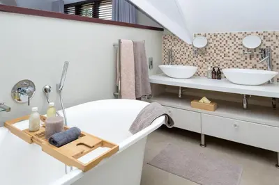 a bathroom with a white tub and two sinks at Eden-Paradys in Stellenbosch