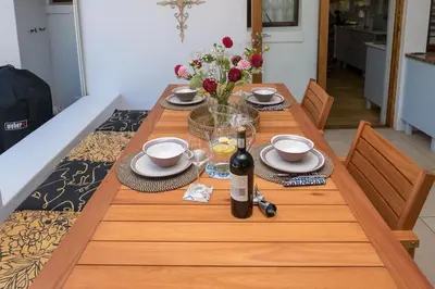 a wooden table with a bottle of wine on it at Eden-Paradys in Stellenbosch
