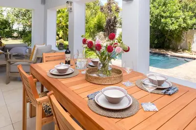 a wooden table with a vase of flowers on it at Eden-Paradys in Stellenbosch