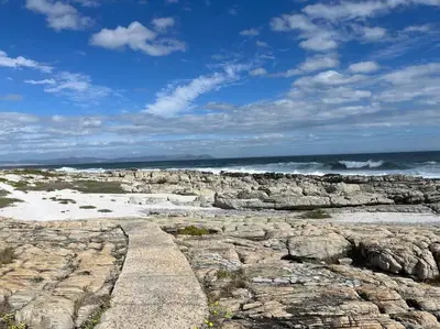 a rocky beach with the ocean in the background at Ocean Breeze @ Hermanus Beach Club in Hermanus