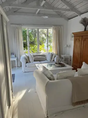 a living room with two white couches and a table at The Treehouse Suite in Hermanus