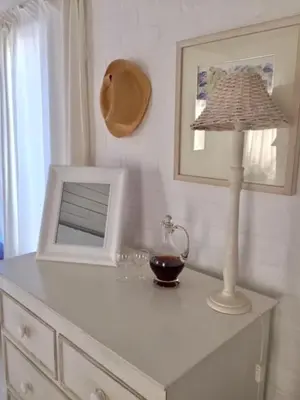 a white dresser with a lamp and a mirror on it at The Treehouse Suite in Hermanus