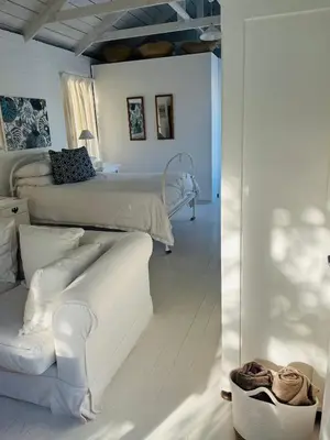 a white room with two beds and a couch at The Treehouse Suite in Hermanus