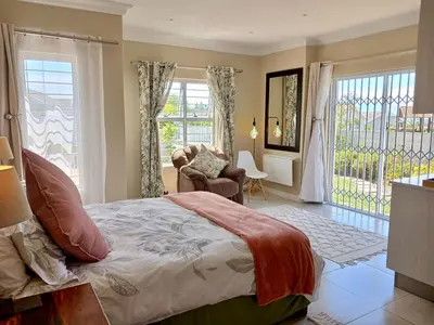 a bedroom with a bed and a living room at 22's Company in Cape Town