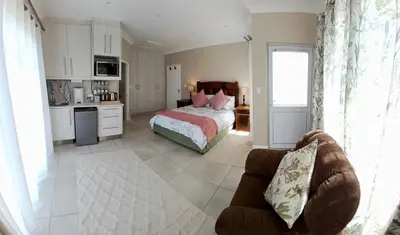 a bedroom with a bed and a couch in a room at 22's Company in Cape Town