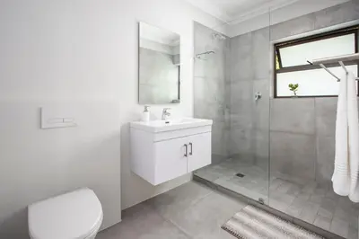 a bathroom with a toilet and a sink and a shower at Wegbreek in Hermanus