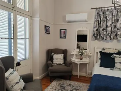 a bedroom with a bed and a chair and a mirror at La Damon 2 in Paarl