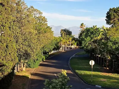 a winding road with trees and a stop sign at Cape Dutch Flair Business unit in Cape Town