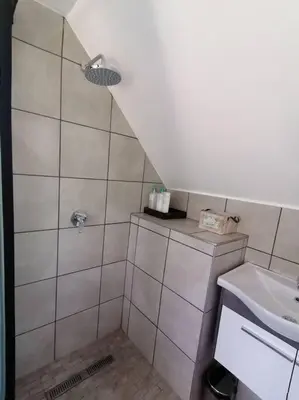 a bathroom with a shower and a sink at Cape Dutch Flair Business unit in Cape Town