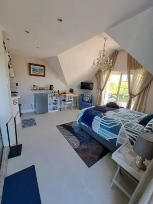 a bedroom with a bed and a living room at Cape Dutch Flair Business unit in Cape Town