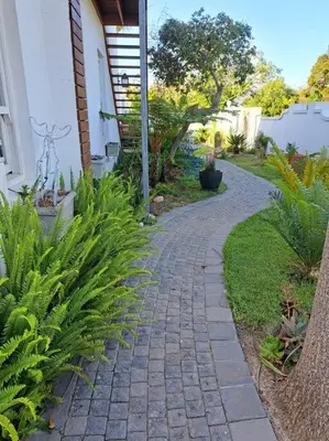 a brick walkway next to a house with plants at Cape Dutch Flair Business unit in Cape Town