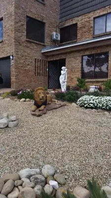 a teddy bear sitting on the ground in front of a building at S & V Accommodation in Cape Town
