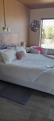 a large white bed in a bedroom with a window at S & V Accommodation in Cape Town