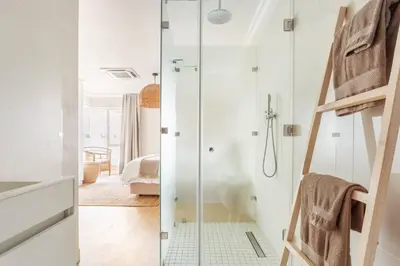 a bathroom with a shower with a glass door at Dolphin Beach cabana Luxe beach cabana voor 4 personen direct aan het strand in Table View