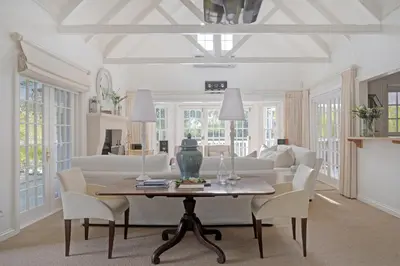 a living room with a table and white furniture at Farm Lorraine Lake Cottage, Loft Cottage and Garden Cottage in Franschhoek
