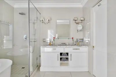 a white bathroom with a sink and a shower at Farm Lorraine Lake Cottage, Loft Cottage and Garden Cottage in Franschhoek