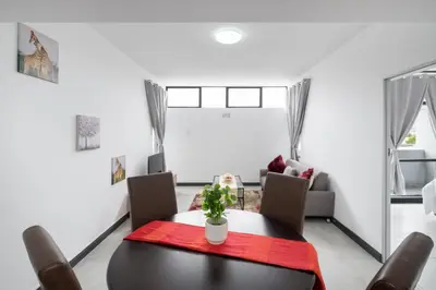 a dining room with a table and chairs at Rest on Millvale guest house in Cape Town