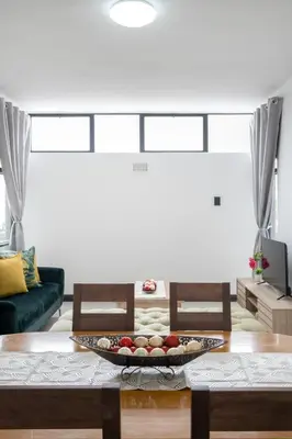 a living room with a table with a tray of fruit on it at Rest on Millvale guest house in Cape Town