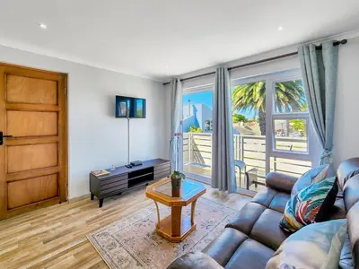 a living room with a couch and a table at Tranquil Family Escape: Pool Balcony in Cape Town