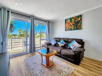 a living room with a couch and a table at Tranquil Family Escape: Pool Balcony in Cape Town