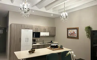 a kitchen with two chandeliers and a counter top at Meerendahl Luxury Apartments at Heritage Square in Durbanville