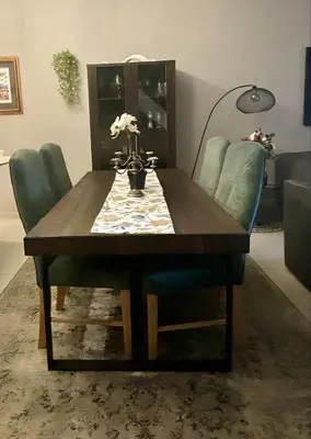 a dining room table with green chairs and a wooden table at Meerendahl Luxury Apartments at Heritage Square in Durbanville
